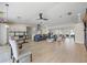 Spacious living space featuring light wood floors, a modern ceiling fan, and an open kitchen concept at 3956 Versailles Dr, Tampa, FL 33634