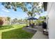 Outdoor patio with dining and seating area, featuring lush green grass, and a waterfront view with a dock at 3956 Versailles Dr, Tampa, FL 33634