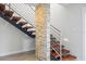 Modern staircase with wood treads, metal railings, and unique stone wall accent at 3956 Versailles Dr, Tampa, FL 33634