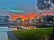 Scenic waterfront view at sunset with vibrant colors reflecting on the calm water and a dock at 3956 Versailles Dr, Tampa, FL 33634