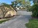 Backyard view of garage with a gravel drive behind a fenced gate at 4205 Helene Pl, Valrico, FL 33594