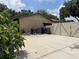 A utility area with water equipment and large trash bins behind a fenced gate at 4205 Helene Pl, Valrico, FL 33594