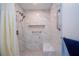 Bathroom with tiled walls and floors, rainfall shower head, grab bars, and built-in bench at 4205 Helene Pl, Valrico, FL 33594