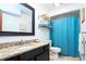 Bright bathroom featuring a granite vanity countertop, toilet, and a blue shower curtain at 4205 Helene Pl, Valrico, FL 33594