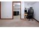 Spacious bedroom featuring a mirrored closet, adjacent office space, and a comfortable black futon sofa at 4205 Helene Pl, Valrico, FL 33594