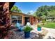 Charming brick home with manicured lawn, lovely landscaping, and inviting front porch with colorful chairs at 4205 Helene Pl, Valrico, FL 33594