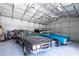 Spacious garage featuring classic cars under a high ceiling with industrial lighting at 4205 Helene Pl, Valrico, FL 33594