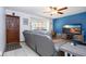 Cozy living room featuring a ceiling fan, blue accent wall and comfortable gray leather furniture at 4205 Helene Pl, Valrico, FL 33594