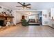 Spacious living room with a stone fireplace, ceiling fan, and neutral tile flooring at 4205 Helene Pl, Valrico, FL 33594