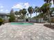 Backyard oasis features a pool and a spacious brick patio surrounded by lush tropical landscaping at 451 Avenida De Mayo, Sarasota, FL 34242