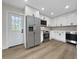 Modern kitchen boasts stainless steel appliances, white cabinets, and ample counter space at 451 Avenida De Mayo, Sarasota, FL 34242