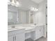 Well-lit bathroom with dual sinks, vanity area, a large mirror, and a separate shower room at 5178 Everlong Dr, Apollo Beach, FL 33572