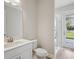 Bright bathroom features a shower, stylish vanity, and a large window showcasing outdoor views at 5178 Everlong Dr, Apollo Beach, FL 33572