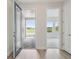 Inviting entryway with open door, showing hardwood floors and view of the lake outside at 5178 Everlong Dr, Apollo Beach, FL 33572