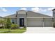 Charming single-story home with a manicured lawn, inviting entrance, and a spacious three-car garage at 5178 Everlong Dr, Apollo Beach, FL 33572