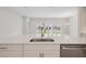 Modern kitchen island with sink, stainless steel appliances, and view of backyard at 5178 Everlong Dr, Apollo Beach, FL 33572
