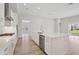 Bright, open-concept kitchen featuring a large island with stainless steel appliances and modern finishes at 5178 Everlong Dr, Apollo Beach, FL 33572