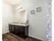 Bathroom vanity with dual sinks, granite countertop and wooden floor at 5521 Yellowfin Ct, New Port Richey, FL 34652