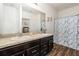 Bathroom with dual sinks, granite countertop, dark cabinets and tub at 5521 Yellowfin Ct, New Port Richey, FL 34652