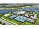 Aerial view showcasing a community pool, tennis courts, basketball court, and lake at 5611 Del Coronado Dr, Apollo Beach, FL 33572