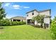 Spacious backyard featuring a lush lawn, garden, patio with hammock and beautiful landscaping at 5611 Del Coronado Dr, Apollo Beach, FL 33572