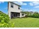 Nice backyard with lush lawn, a patio with a hammock, plants, and sliding glass doors at 5611 Del Coronado Dr, Apollo Beach, FL 33572