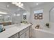 Bright bathroom featuring a soaking tub, glass shower, double vanity with white countertops and gray cabinets at 5611 Del Coronado Dr, Apollo Beach, FL 33572