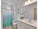 Well-lit bathroom showcasing a white vanity, shower with teal curtain, and coordinated coastal decor at 5611 Del Coronado Dr, Apollo Beach, FL 33572