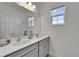 Bright bathroom featuring a double sink vanity, a large mirror, and natural light from the window at 5611 Del Coronado Dr, Apollo Beach, FL 33572