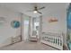 Serene bedroom with a crib, comfortable chair, and decorative aquatic theme at 5611 Del Coronado Dr, Apollo Beach, FL 33572
