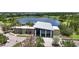 Aerial view of a modern community center with a lake in the background and trees and landscaping at 5611 Del Coronado Dr, Apollo Beach, FL 33572