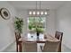 Bright dining room featuring modern light fixture, table, and chairs with a view of the landscaped backyard at 5611 Del Coronado Dr, Apollo Beach, FL 33572