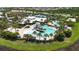Aerial view of a resort-style pool with a slide, a splash pad, and lounge areas surrounded by palm trees at 5611 Del Coronado Dr, Apollo Beach, FL 33572