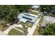 Aerial view of the house showcases the solar panels, fenced in yard and mature trees at 5895 16Th N St, St Petersburg, FL 33703