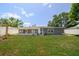 Fenced backyard with lush grass and a gray house, perfect for outdoor activities at 5895 16Th N St, St Petersburg, FL 33703