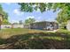 Spacious backyard featuring a gray house, a patio, and lush green grass at 5895 16Th N St, St Petersburg, FL 33703