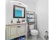 Cozy bathroom features a granite countertop, bronze fixtures and black metal shelving at 5895 16Th N St, St Petersburg, FL 33703
