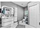Modern bathroom featuring an illuminated vanity, a sleek toilet, and ample storage at 5895 16Th N St, St Petersburg, FL 33703