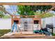 Brick oven under wooden pergola with chairs and equipment in the backyard at 5895 16Th N St, St Petersburg, FL 33703