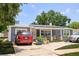 Charming single-story home with a cozy front porch, lush landscaping, and solar panels for energy efficiency at 5895 16Th N St, St Petersburg, FL 33703