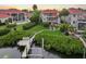 Scenic backyard featuring a private dock, manicured lawn, mature trees, and a glimpse of the home's exterior balconies at 6107 Marbella Blvd, Apollo Beach, FL 33572