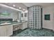 Double sinks in bathroom with green marble countertops and a decorative glass block shower at 6107 Marbella Blvd, Apollo Beach, FL 33572