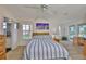 Bright bedroom featuring two windows, wood floors, and a glimpse into the bathroom at 6107 Marbella Blvd, Apollo Beach, FL 33572