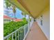 Long, open-air hallway with white railings and beige carpet, providing access to residences with tranquil neighborhood views at 6107 Marbella Blvd, Apollo Beach, FL 33572