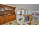 View of a loft area with a wood bar, white chair, glass table and staircase at 6107 Marbella Blvd, Apollo Beach, FL 33572