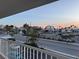 Balcony view showcases a vibrant street view with palm trees, businesses and a colorful sky at 6161 Gulf Winds Dr # 347, St Pete Beach, FL 33706