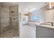 Bright bathroom featuring a glass shower, freestanding tub, dual vanity, and elegant chandelier beneath a large skylight at 6186 Seaside Dr, New Port Richey, FL 34652