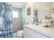 Bright bathroom featuring tiled shower with patterned curtain and white vanity with ample counter space at 6186 Seaside Dr, New Port Richey, FL 34652