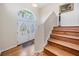 Home entryway with decorative glass double doors and wooden staircase at 6186 Seaside Dr, New Port Richey, FL 34652