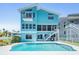 Back of a waterfront home with a pool and stairs leading to a second-story balcony at 6186 Seaside Dr, New Port Richey, FL 34652
